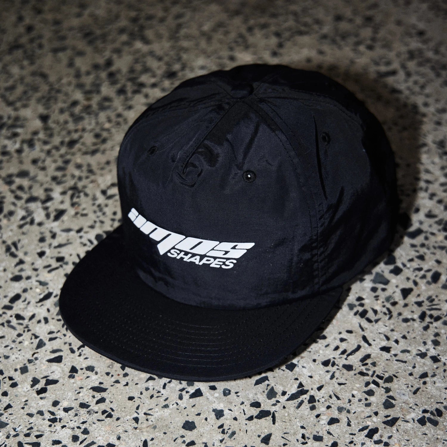 Black surf cap with Amos Shapes logo in white on the front