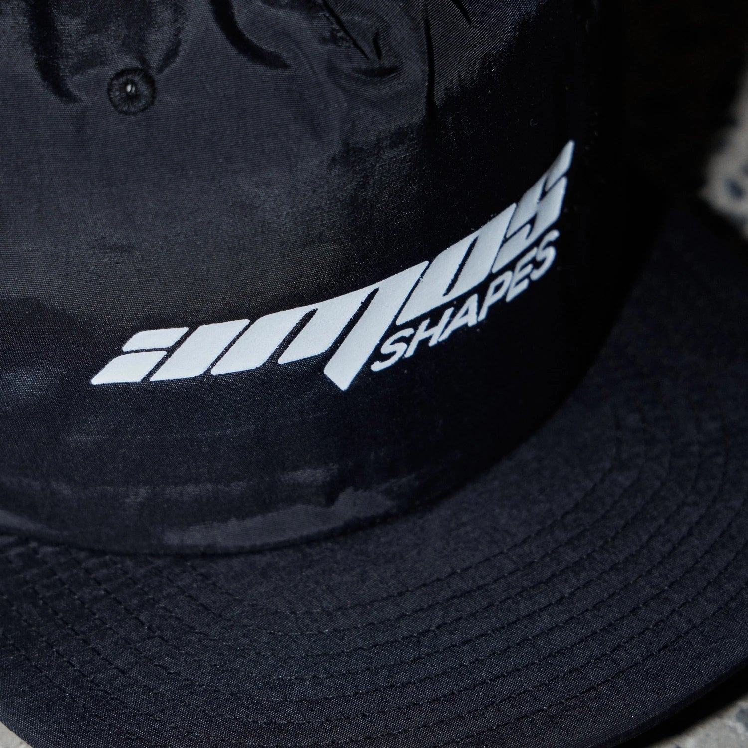 Black surf cap with Amos Shapes logo in white on the front