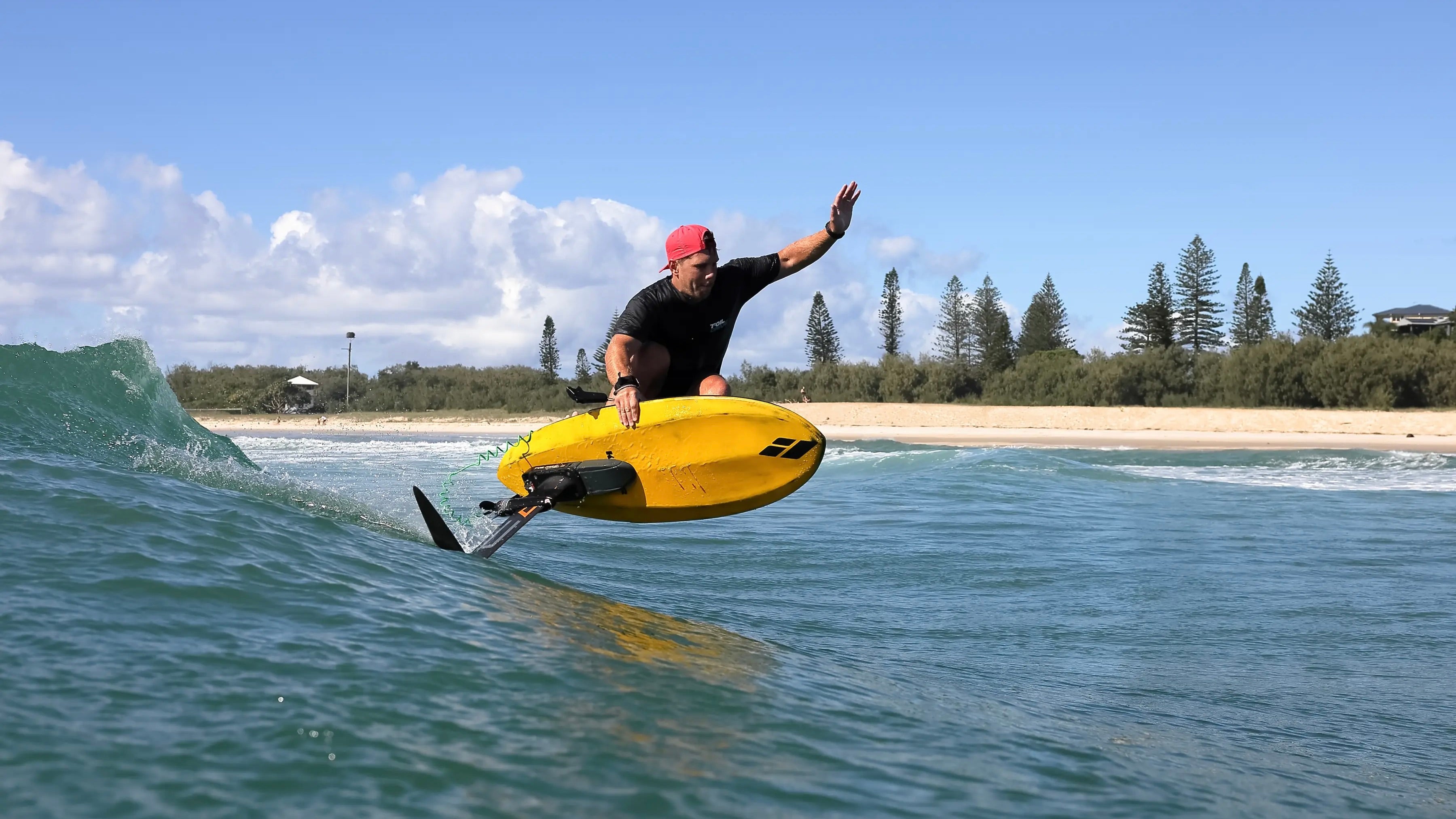 Hydrofoiler for Amos Shapes Dave West using the Foil Drive Assist Max Full Kit foiling a wave on a yellow hydrofoil board
