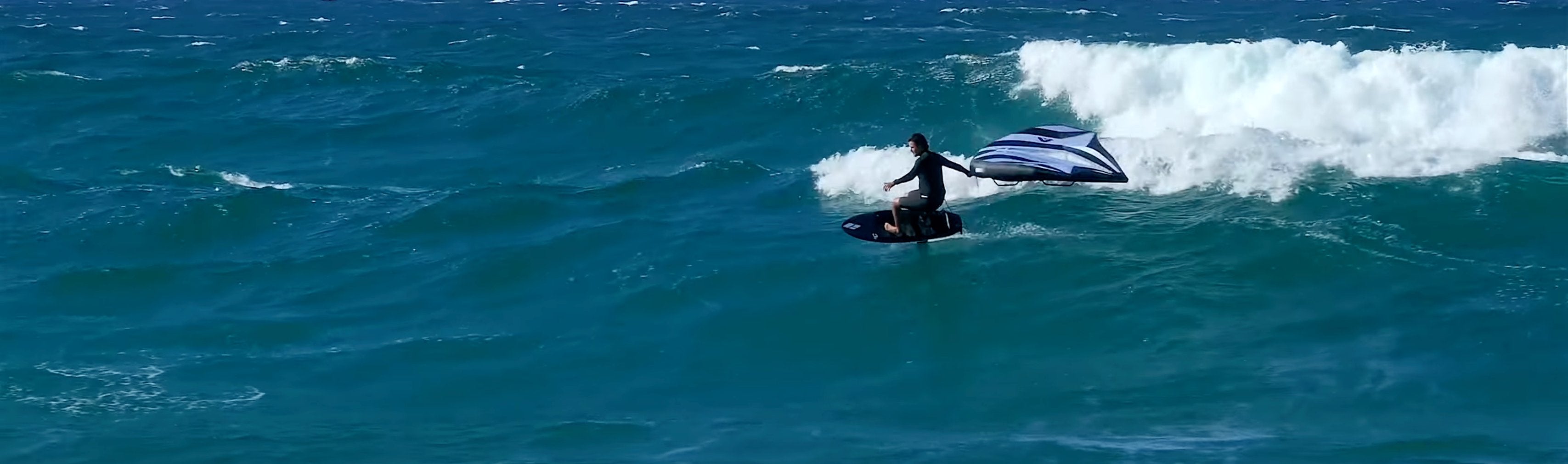 Adam Bennets Pro foiler riding a Wing Foilbaord from Amos Shapes on a wave