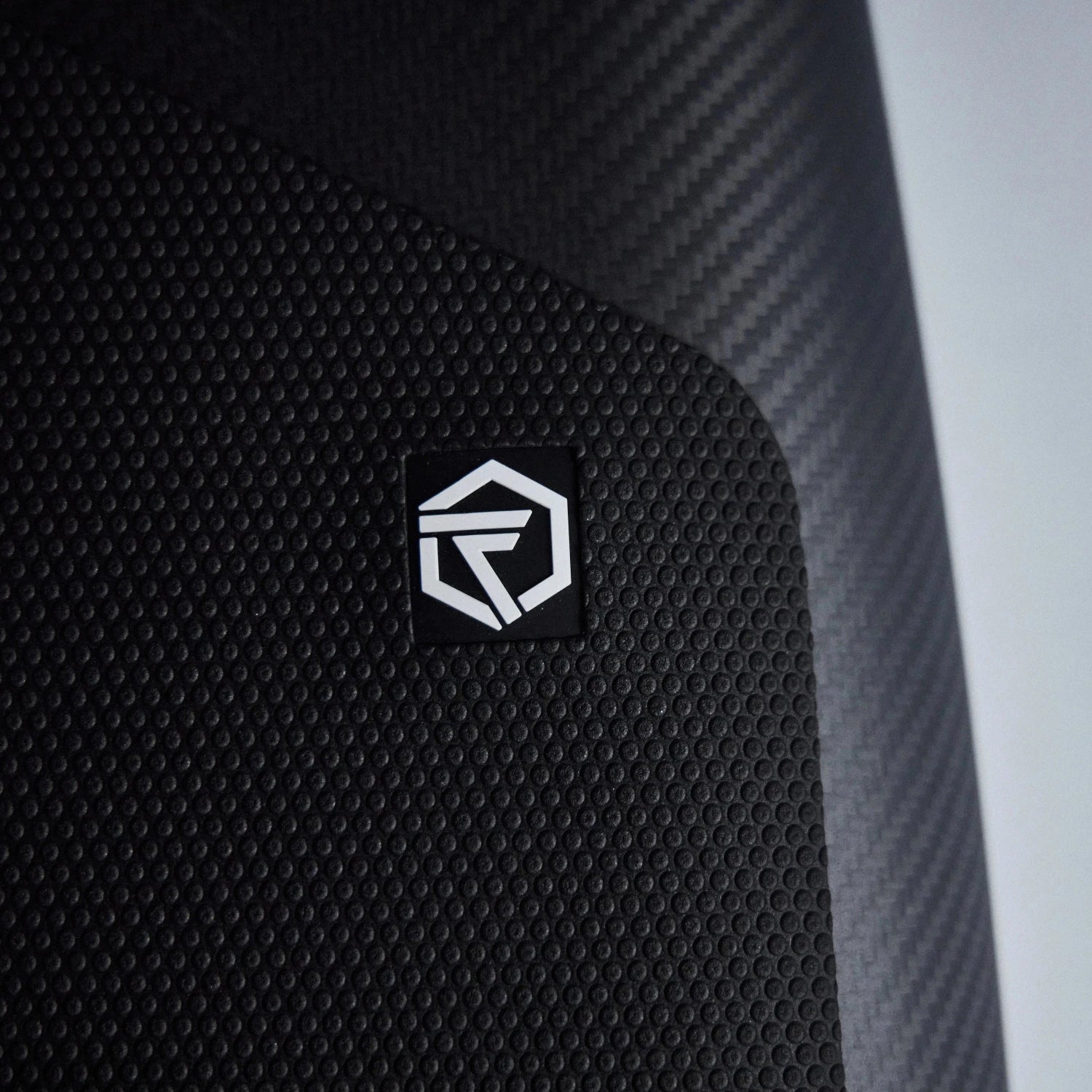 Close up shot of the Foil Tec logo in white on a black foilboard traction pad