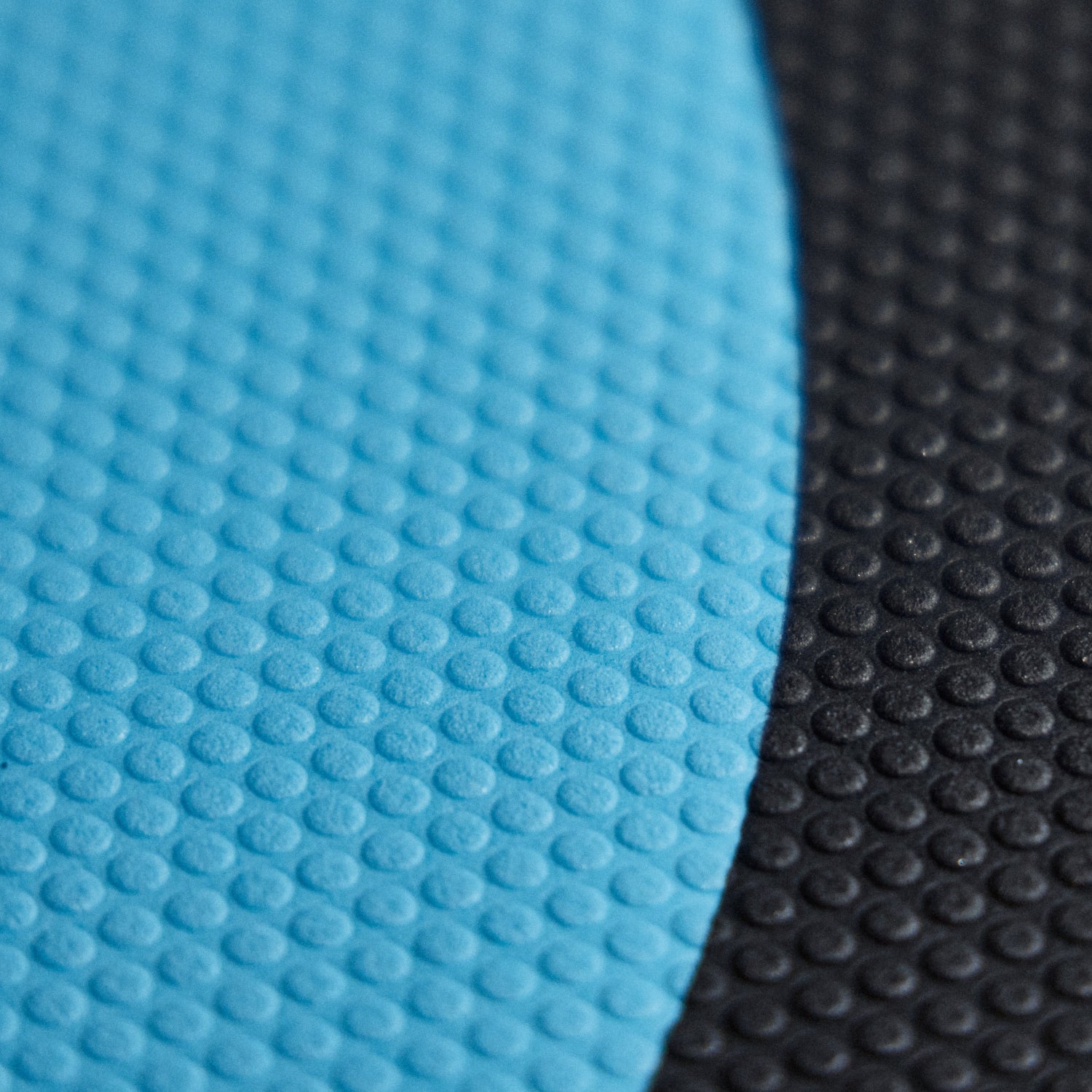 Close up shot of a black and ocean blue Josh Ku foilboard deck grip showing its dotted texture